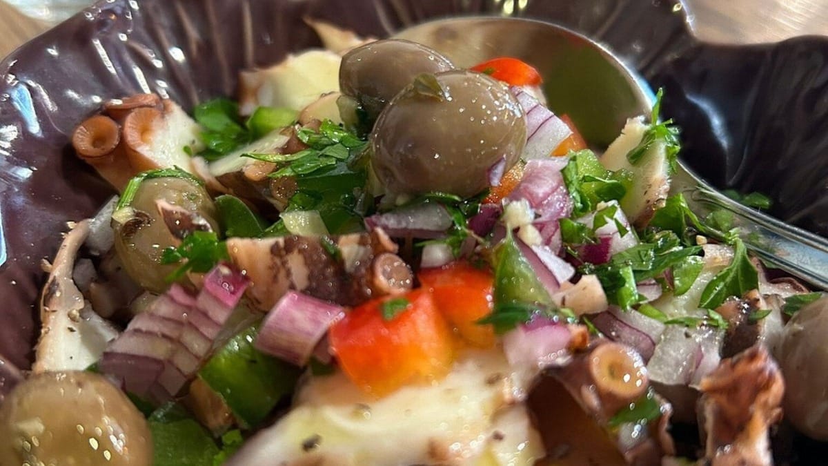 Ensalada de pulpo del Algarve con cebolla, perejil y aceite de oliva servida en un bol