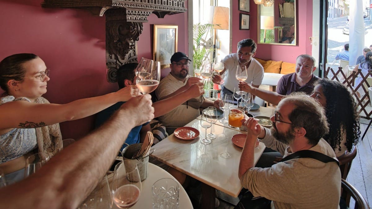 Grupo pequeno brindando com copos de vinho durante uma experiência de prova e Fado ao vivo no Porto por Cooltour Oporto