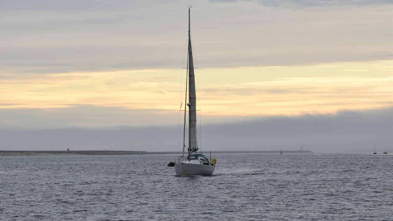 Sailboat cruising the Douro River at sunset in Porto