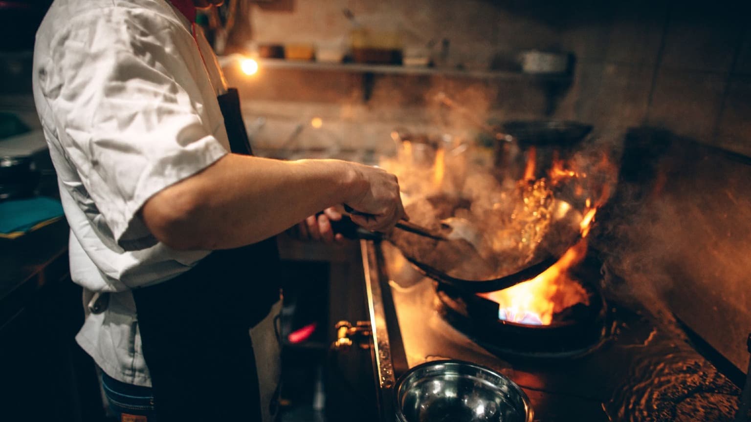 Um chefe num restaurante tradicional português a cozinhar com paixão, mostrando a autenticidade da cozinha local para além do reconhecimento Michelin.