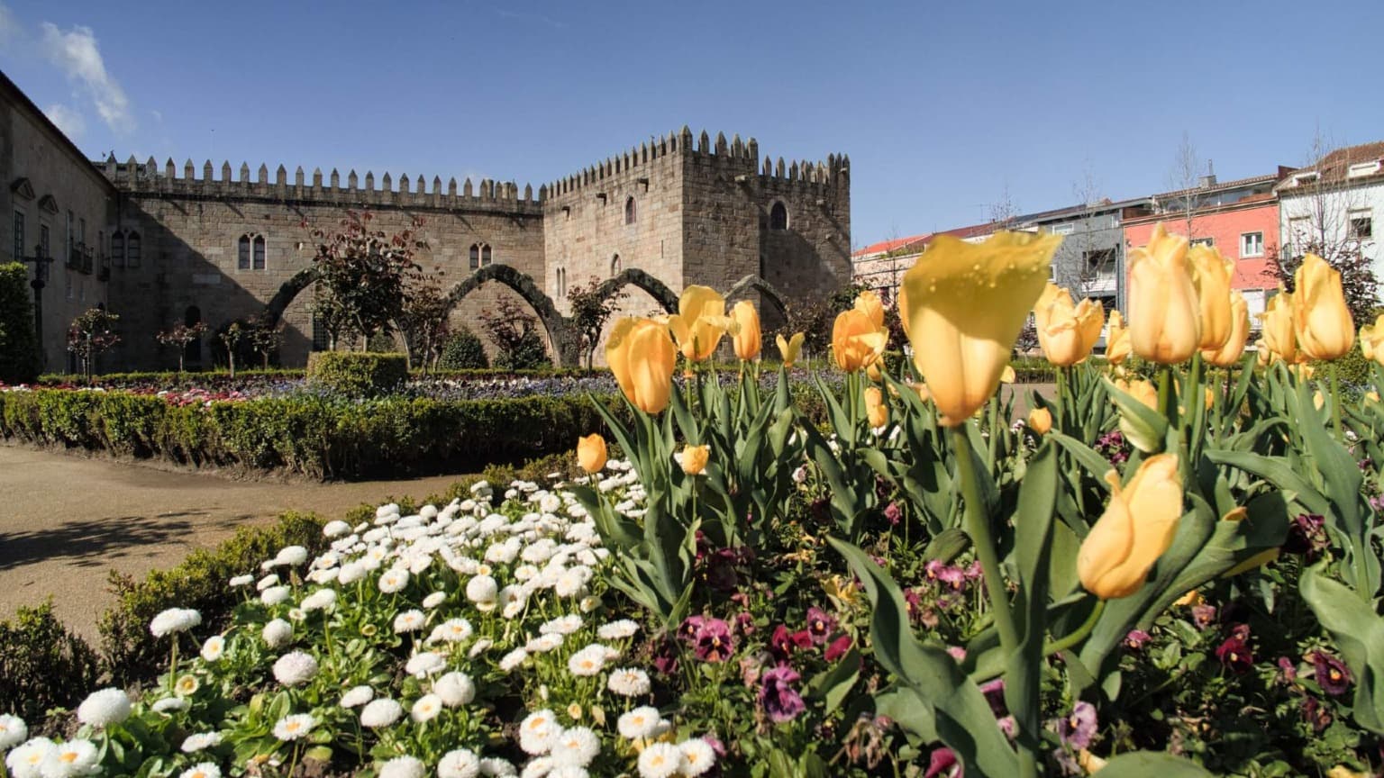 Jardines del Palacio Arzobispal de Braga, con murallas medievales y parterres de flores en el centro de la ciudad