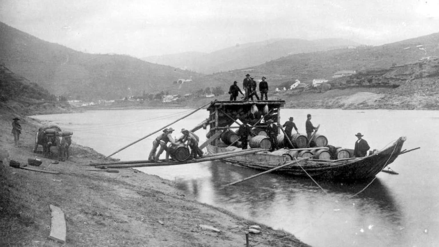 Des ouvriers chargeant des tonneaux de vin de Porto sur un bateau Rabelo traditionnel à Régua, dans la vallée du Douro, au début du XXe siècle
