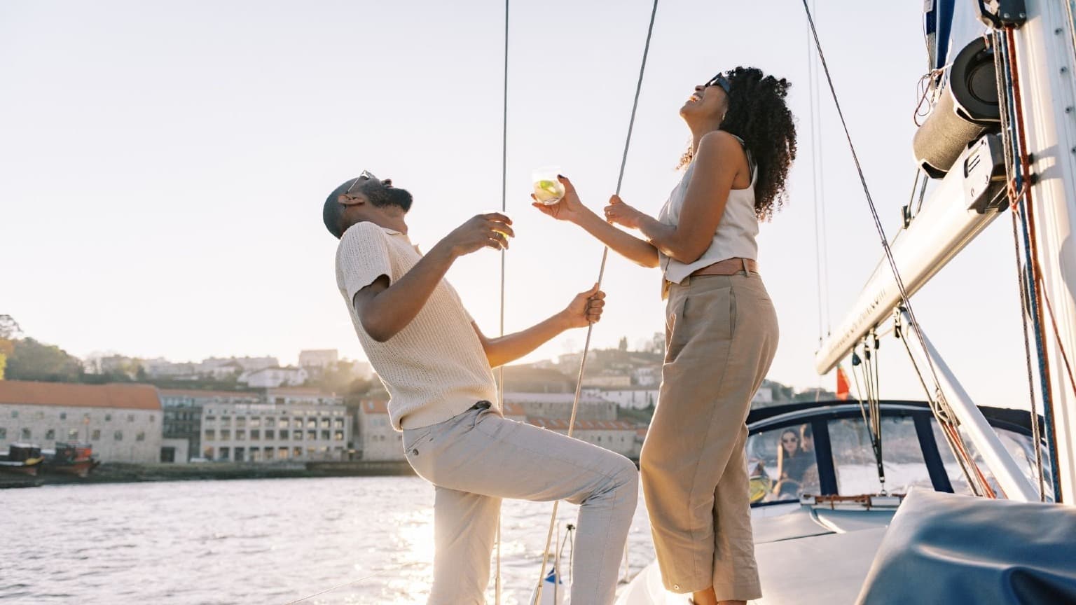 Casal a desfrutar de um cruzeiro de barco ao pôr do sol no rio Douro, no Porto