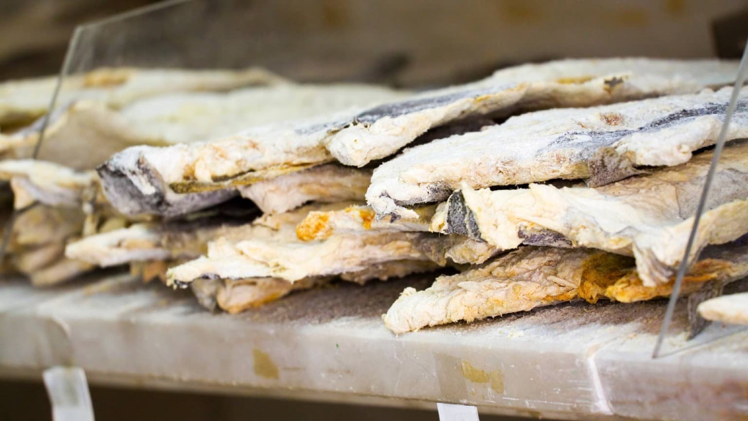 Traditional salted and dried bacalhau displayed for sale in a Portuguese market