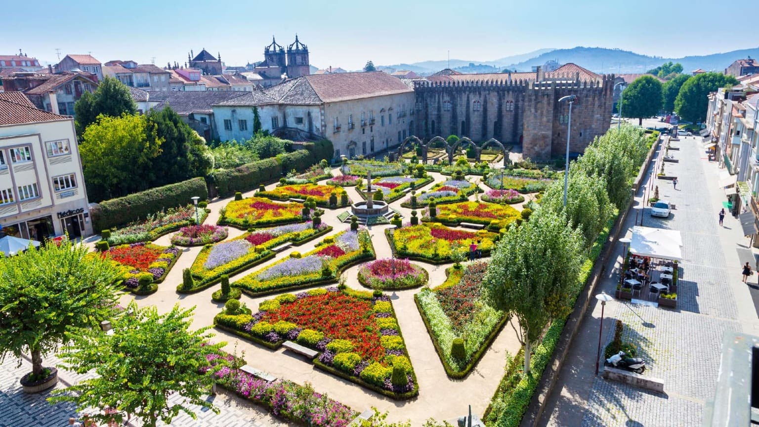 El Jardín de Santa Bárbara, en el centro de Braga, con flores de colores y el Palacio Arzobispal medieval, en el norte de Portugal