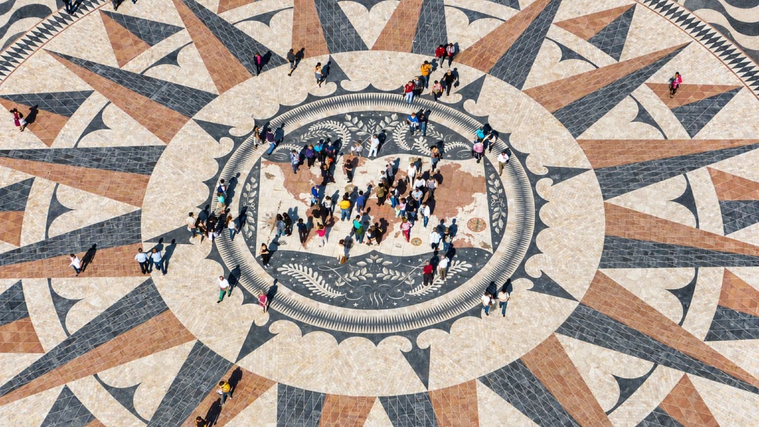 Visitantes a explorar o mapa das descobertas portuguesas em Belém, Lisboa