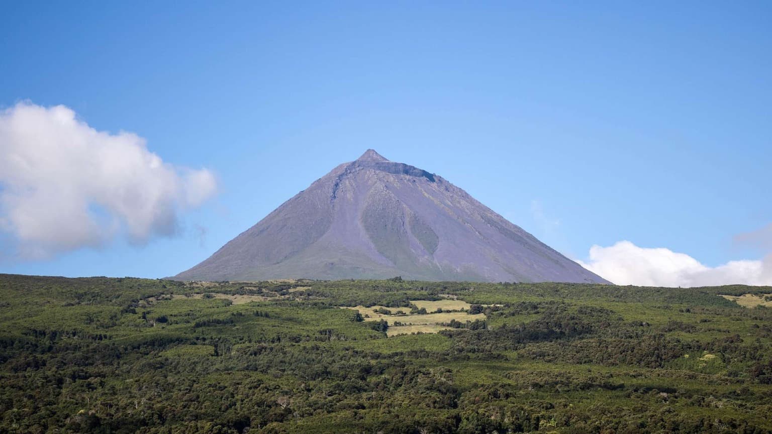 O Monte Pico elevando-se acima da paisagem verdejante da Ilha do Pico, nos Açores