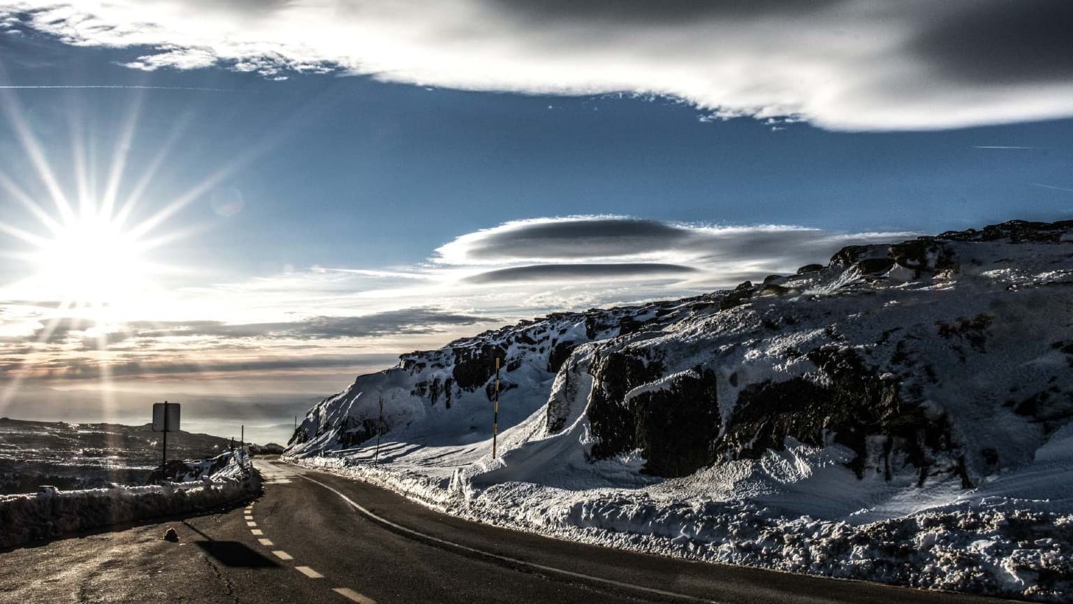 Estrada sinuosa e nevada com vistas panorâmicas através das montanhas da Serra da Estrela, o ponto mais alto de Portugal continental.