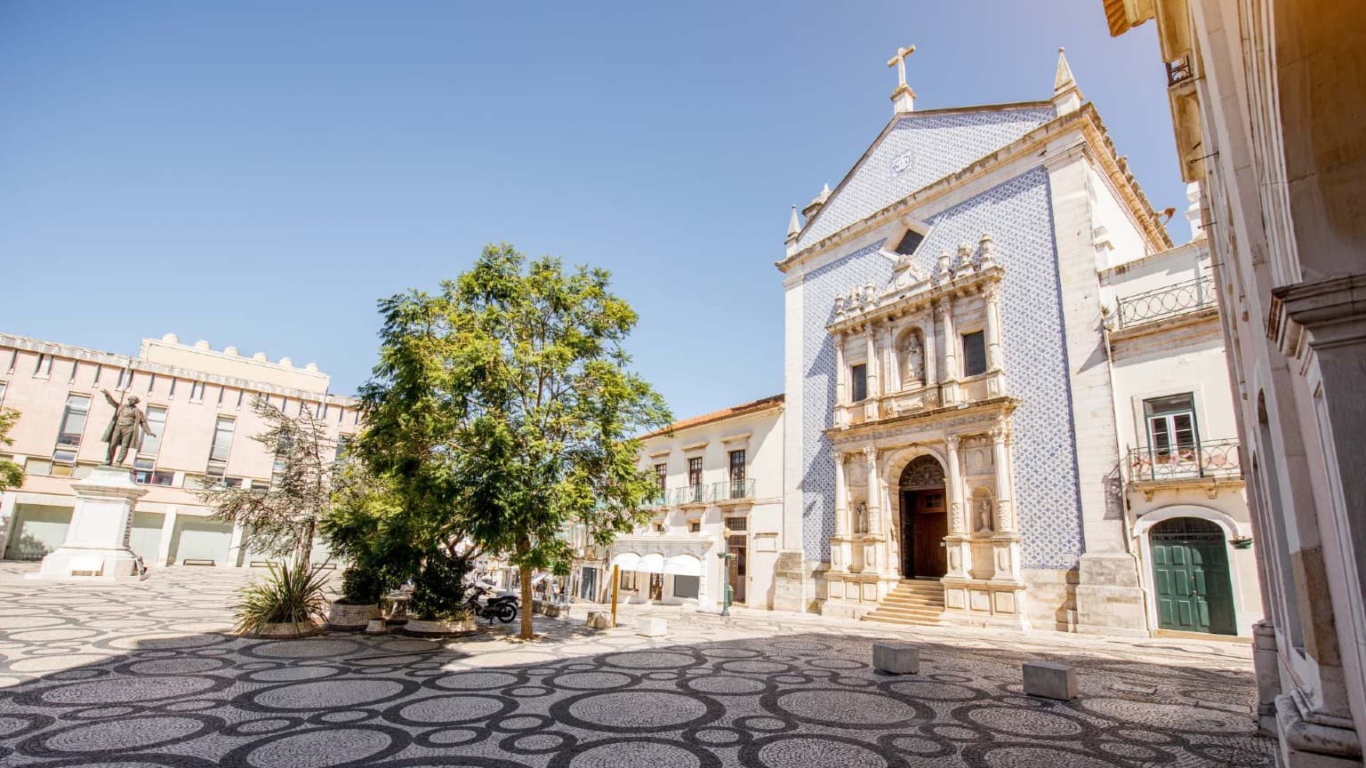 Praça da República em Aveiro, com o seu pavimento de pedra padronizado e a Igreja da Misericórdia revestida de azulejos.