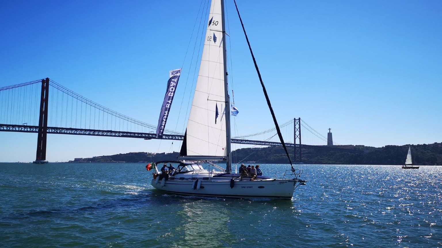 Iate à vela no rio Tejo, perto da Ponte 25 de Abril, em Lisboa