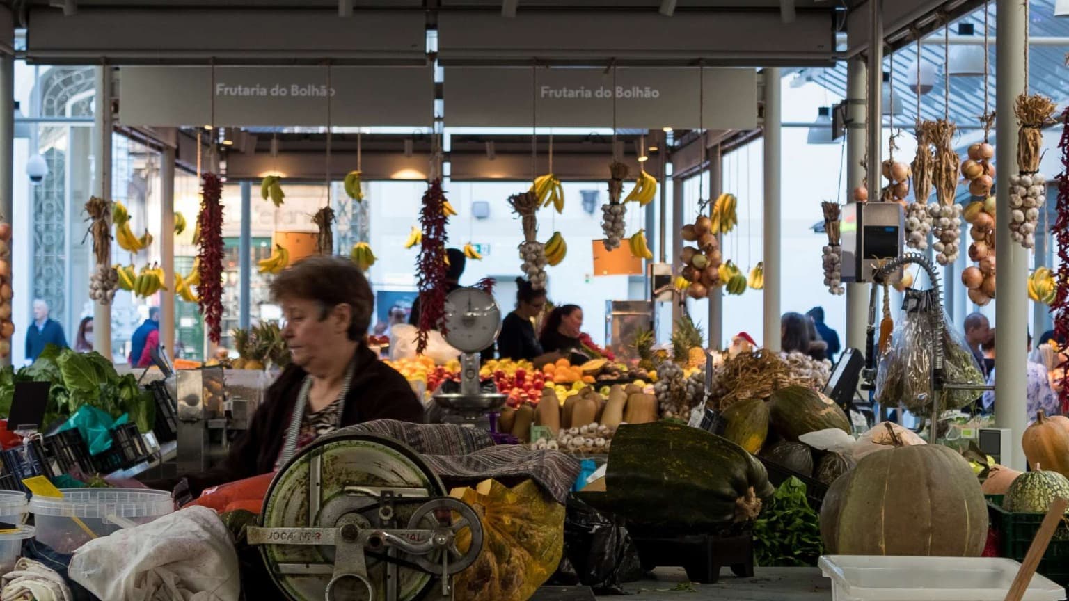Traditional produce stalls and vendors inside Mercado do Bolhão historic market in Porto