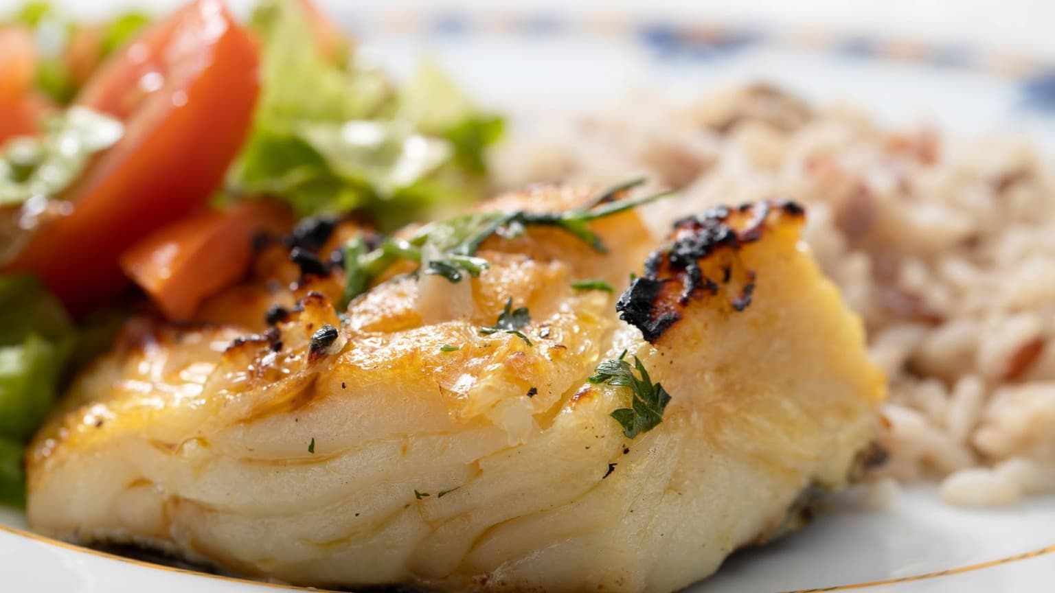 Traditional grilled bacalhau served with olive oil and Portuguese side dishes