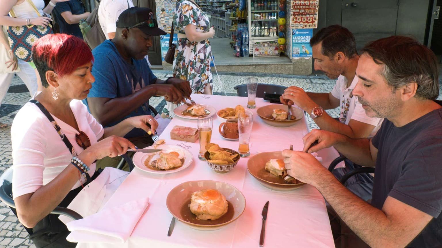 Huéspedes degustando una Francesinha durante un tour gastronómico guiado por Oporto en el centro histórico de la ciudad