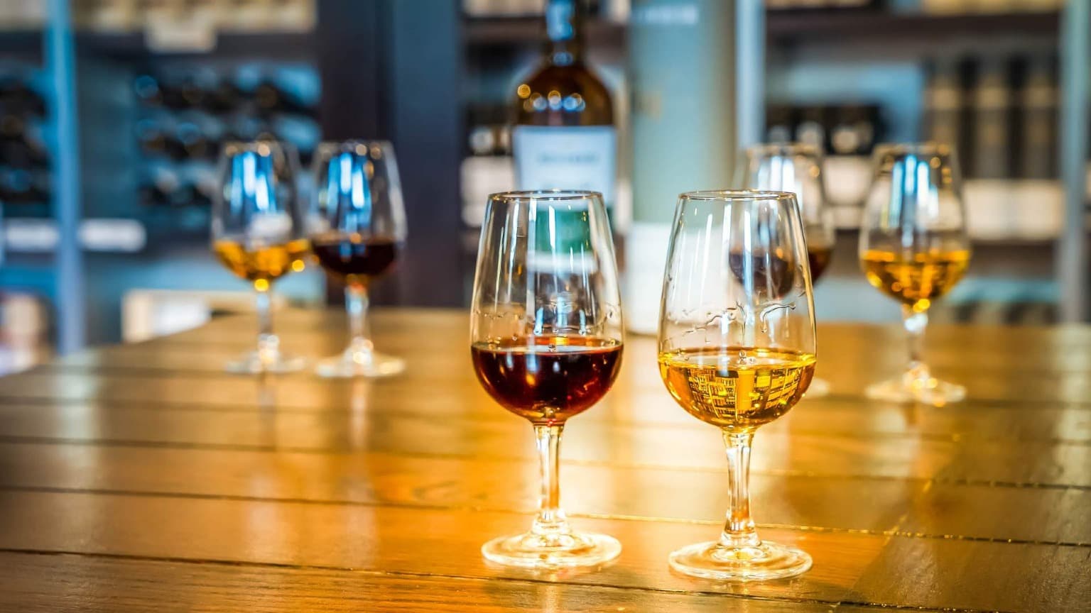 Diferentes estilos de vinho do Porto servidos em copos durante uma degustação após uma visita guiada à adega