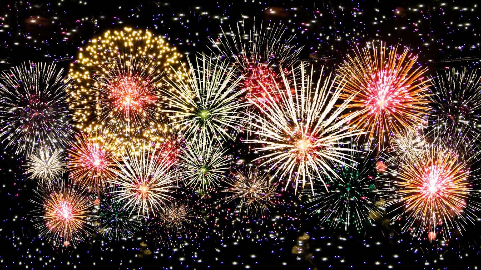 Fogos de artifício coloridos explodem no céu noturno durante a celebração da véspera de Ano Novo no Porto