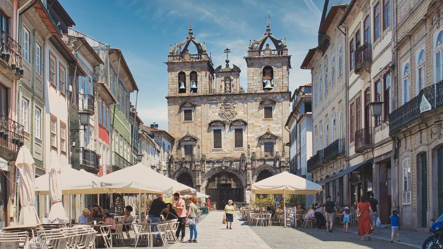 A Sé de Braga com as suas torres góticas e uma praça animada com esplanadas.