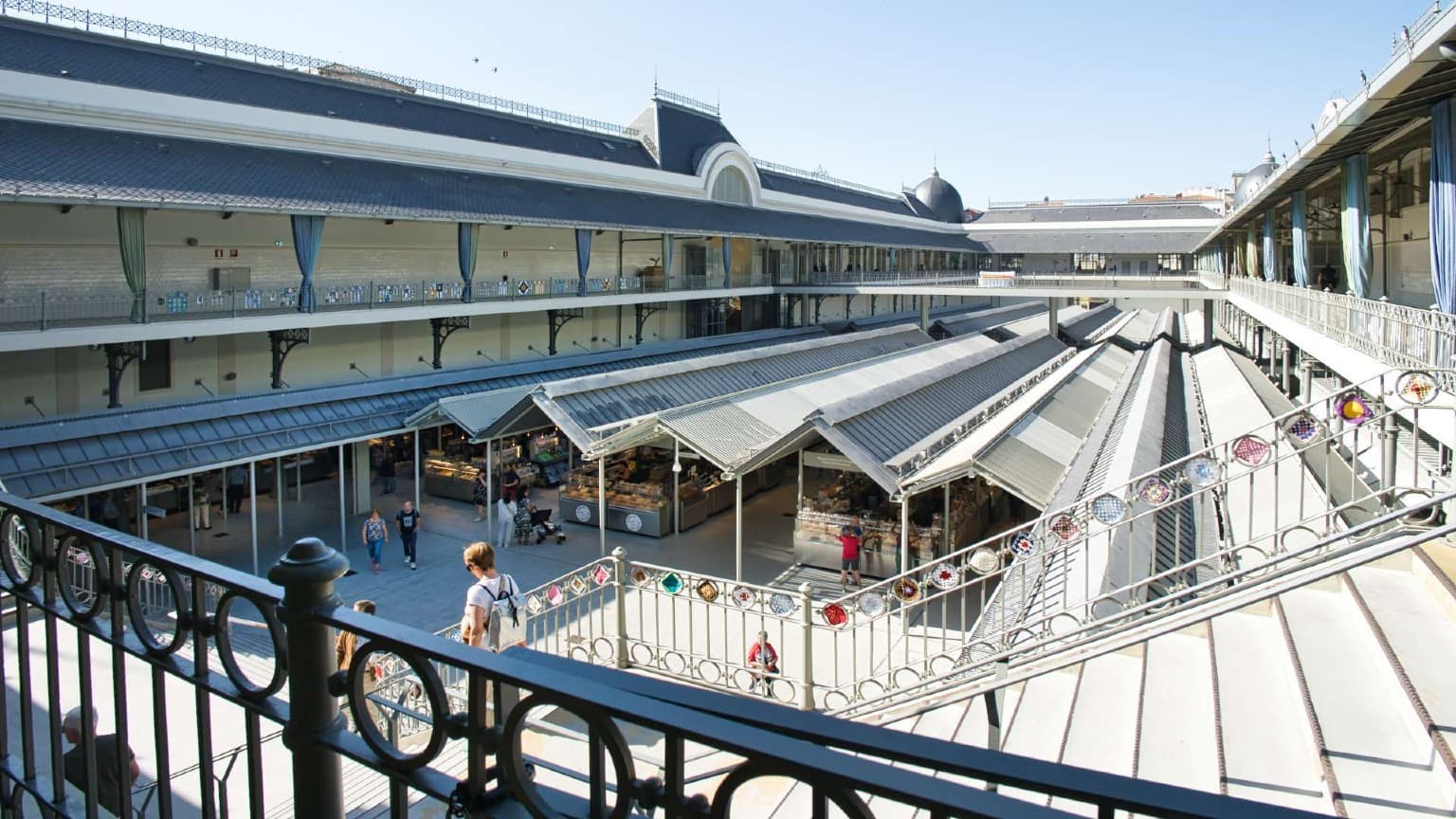 Vista da galeria superior do Mercado do Bolhão, mostrando o pátio histórico do mercado e as bancas no Porto