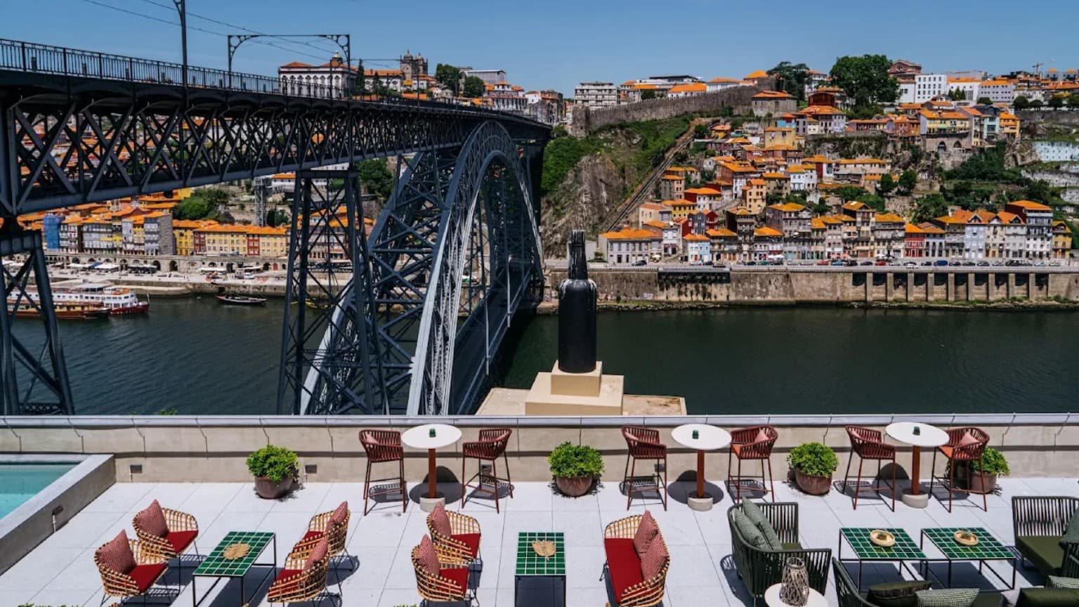 Terraza con mesas con vistas al puente Dom Luís I y a la Ribeira de Oporto desde el hotel Vincci Ponte de Ferro en Vila Nova de Gaia.