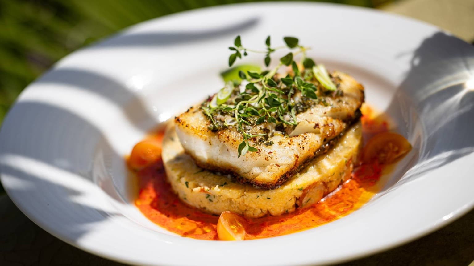 Prato contemporâneo de bacalhau português servido no Coisa Linda, em Tavira