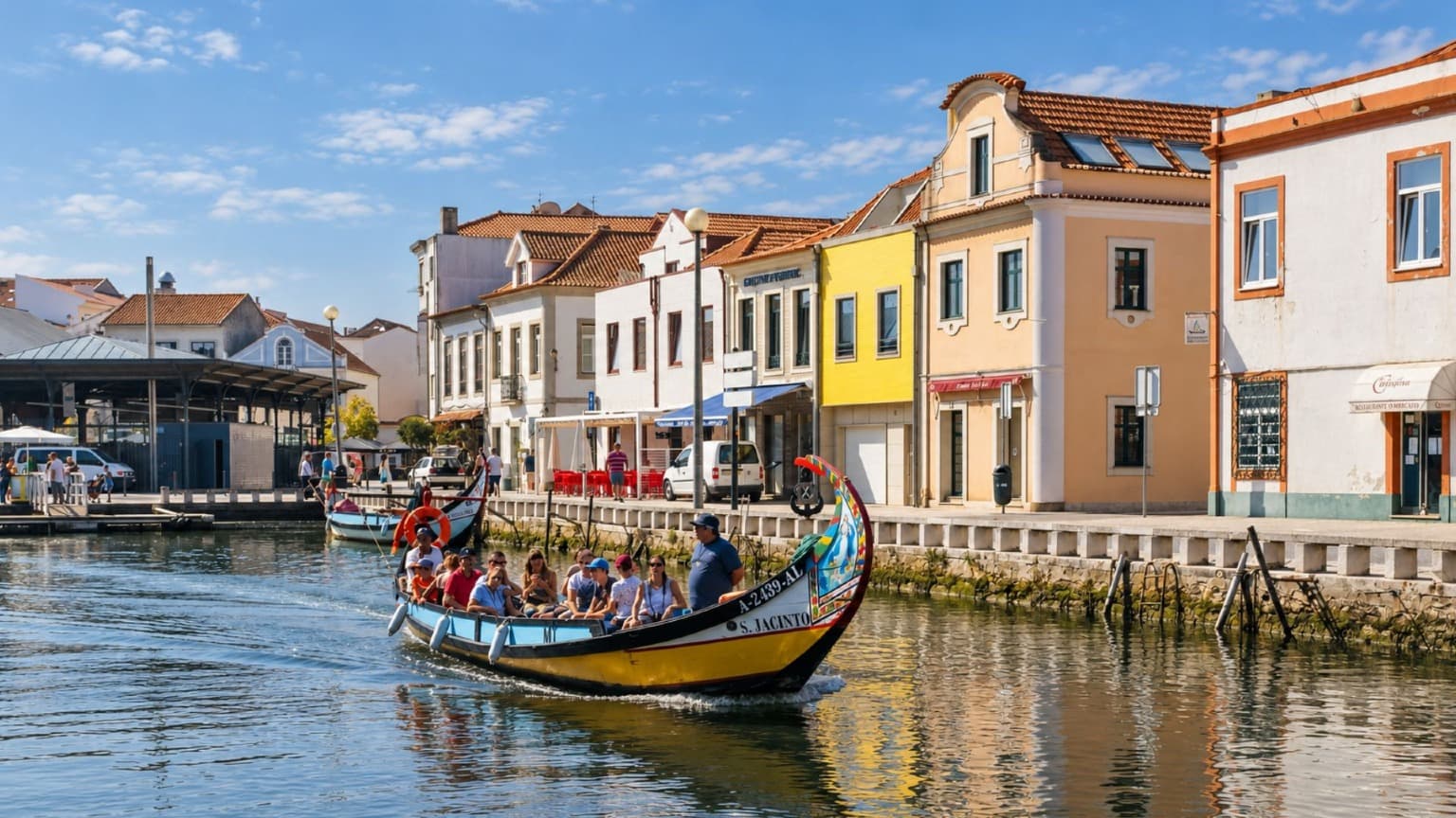 Un colorido barco tradicional «moliceiro» navegando por un canal entre las casas de Aveiro