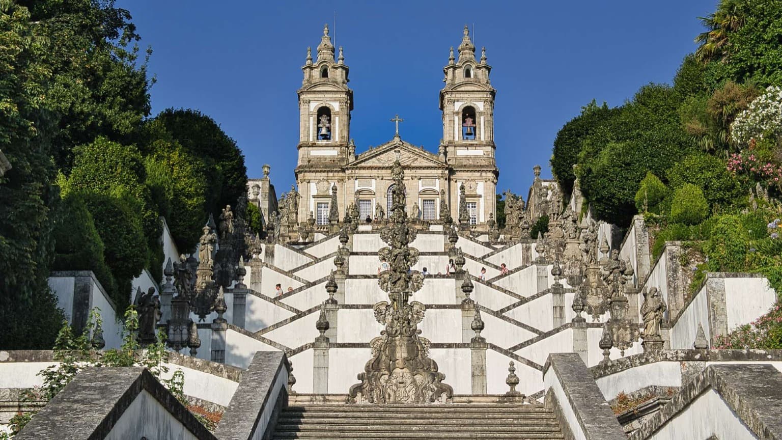 Escadaria do Bom Jesus do Monte em Braga, com degraus barrocos e estátuas religiosas representando a Via Sacra
