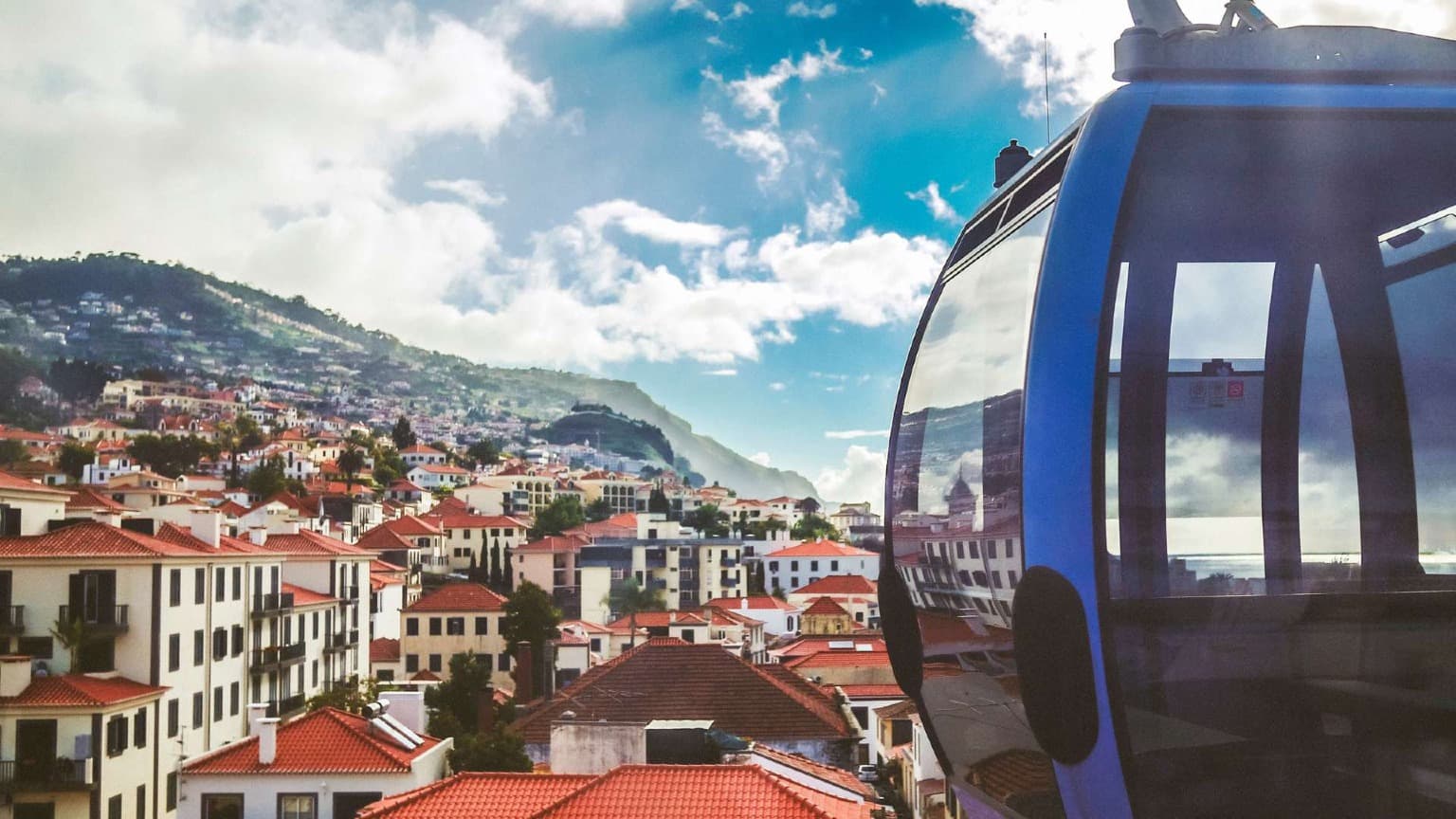 Téléphérique surplombant les toits en terre cuite et les collines de Funchal, Madère