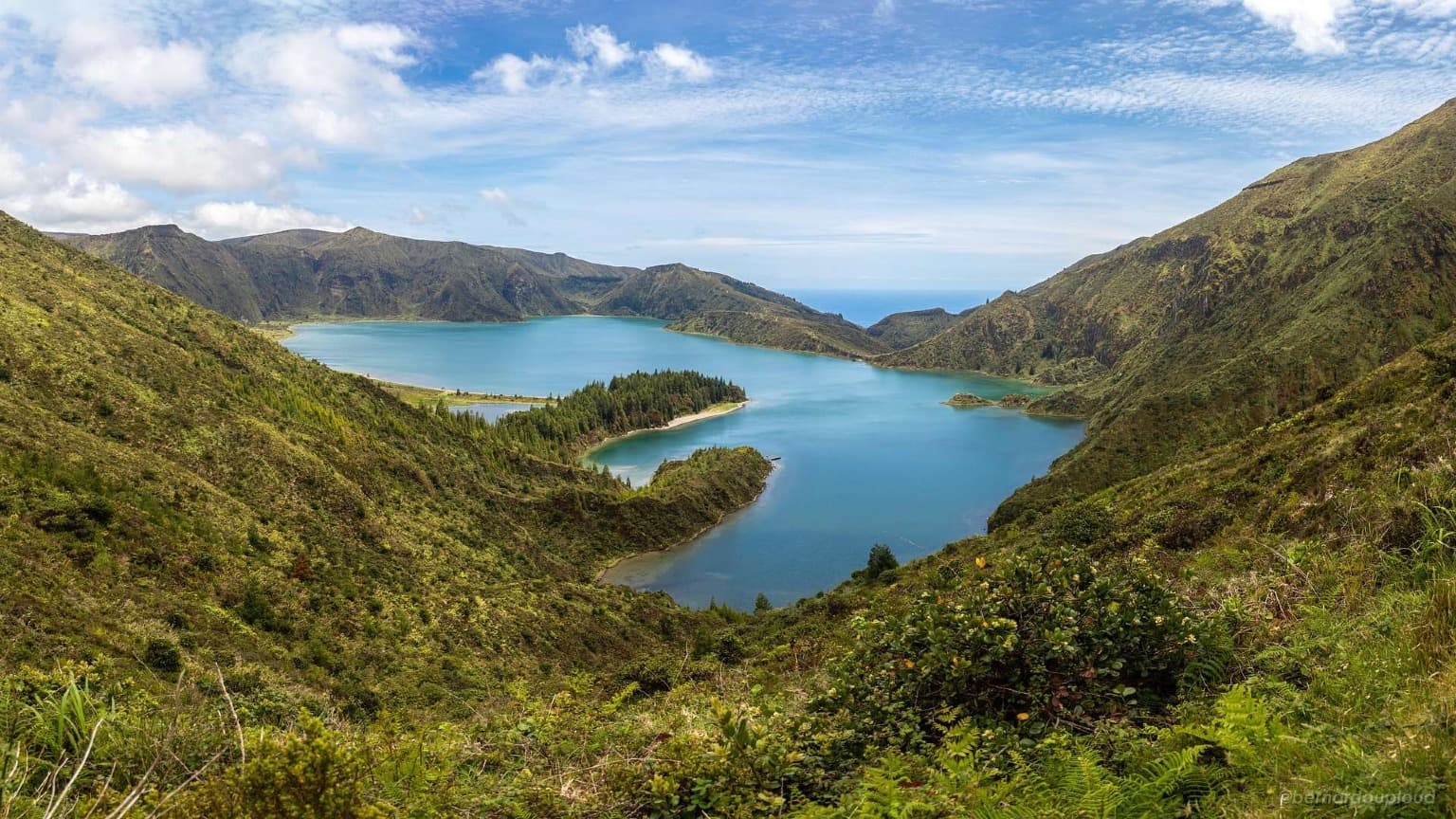 Vista panorâmica da cratera da Lagoa do Fogo, rodeada por montanhas, em São Miguel, Açores