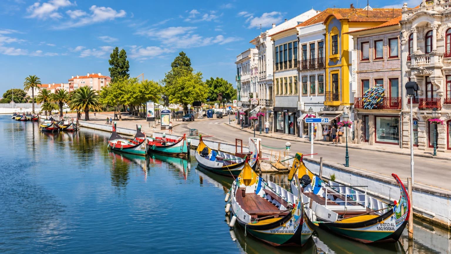 Barcos moliceiros en un canal de Aveiro, con coloridos edificios históricos a lo largo de la ribera