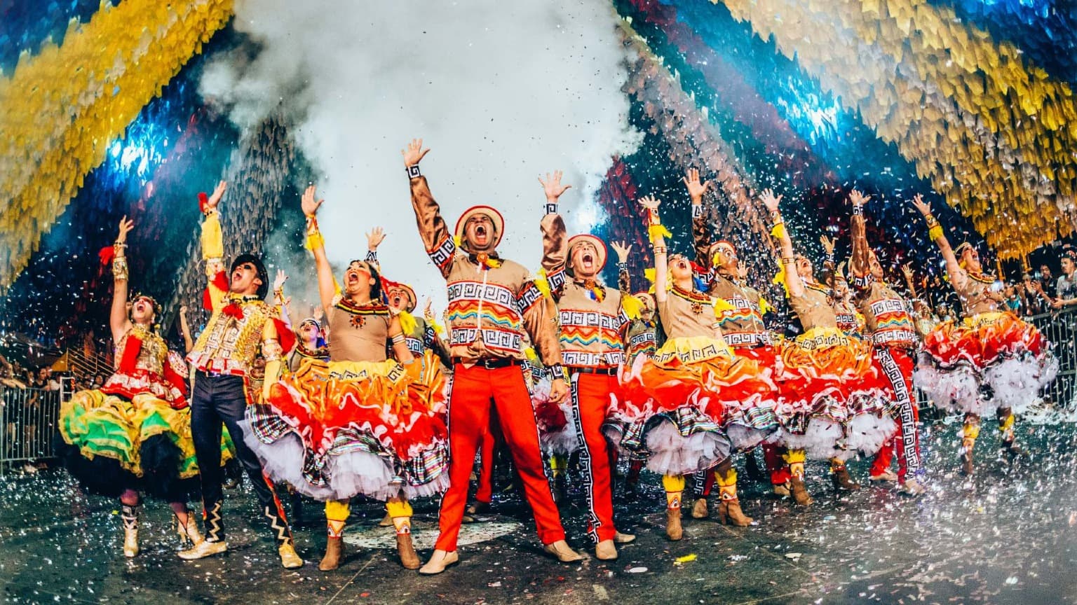 Bailarines tradicionales celebrando las Fiestas de San Antonio en la Avenida da Liberdade de Lisboa, con trajes coloridos y confeti.