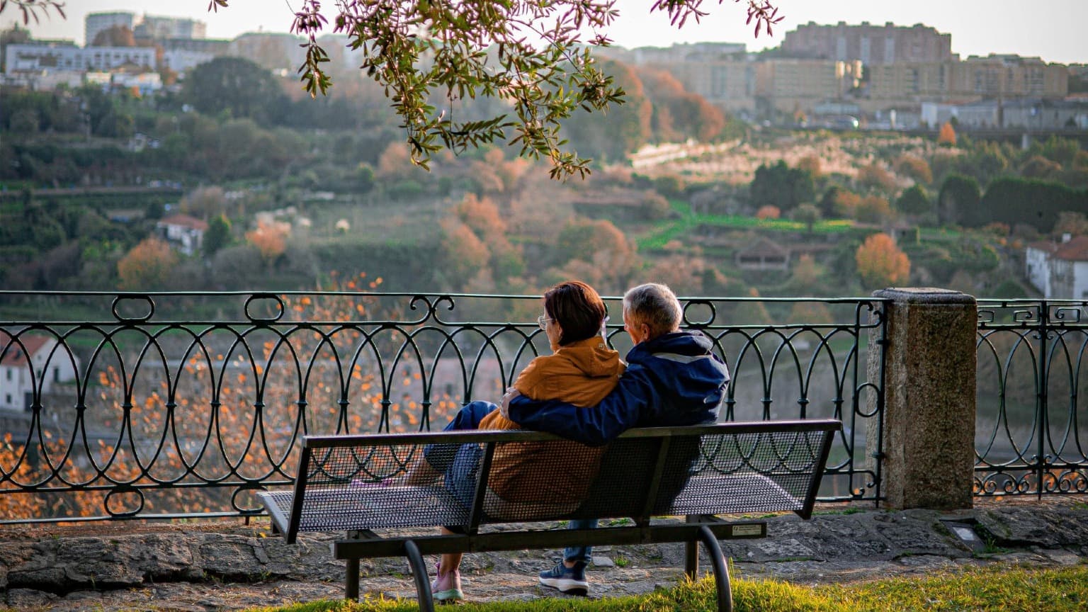 Couple sitting together at a garden viewpoint overlooking Porto
