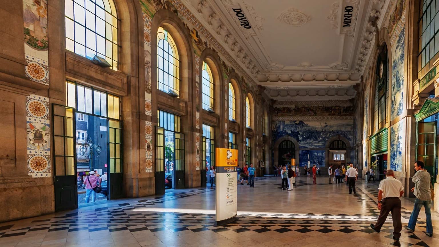 Intérieur de la gare São Bento à Porto avec ses panneaux historiques en azulejos.