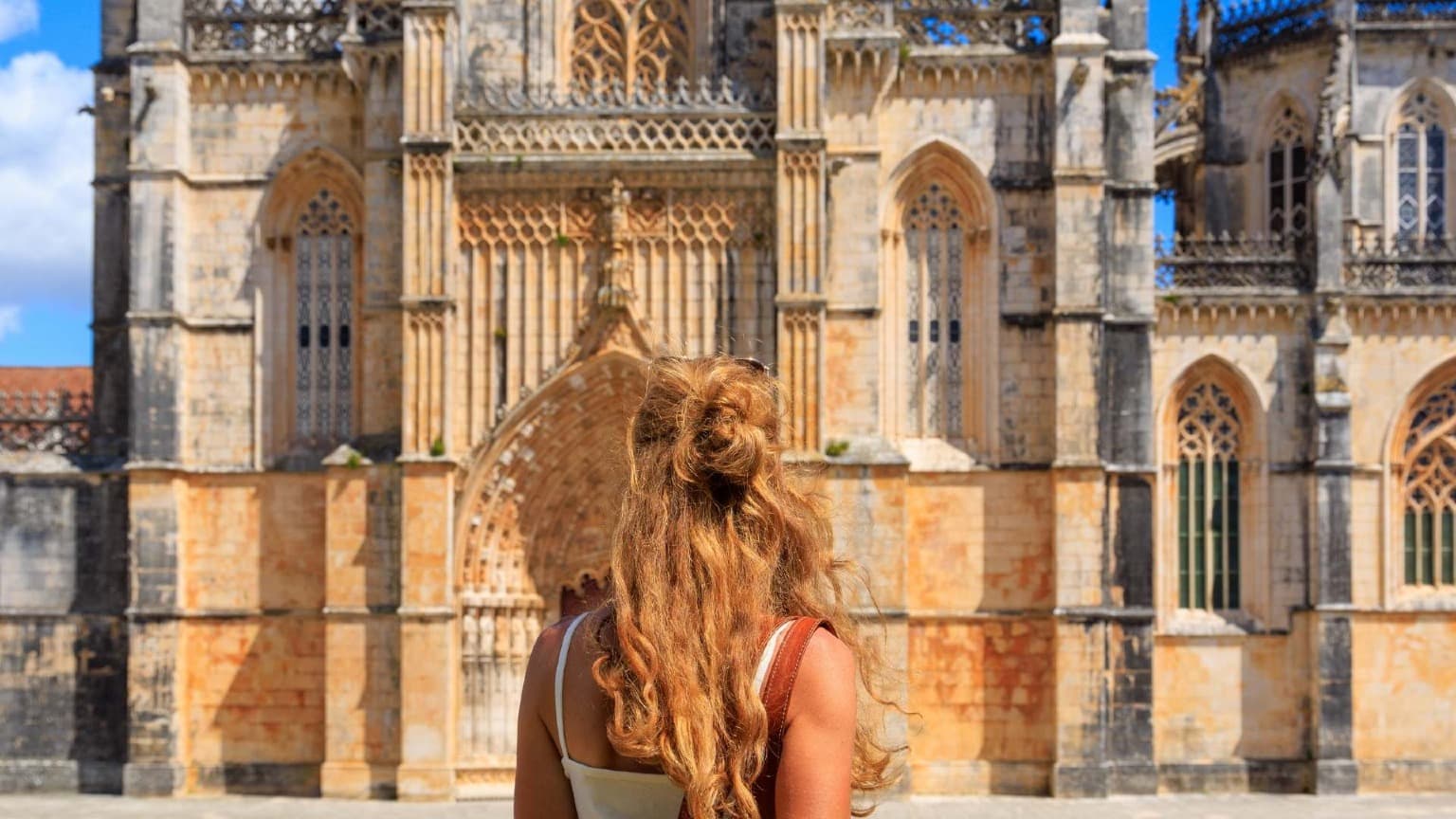 Viajante a admirar a arquitetura do Mosteiro da Batalha, em Portugal