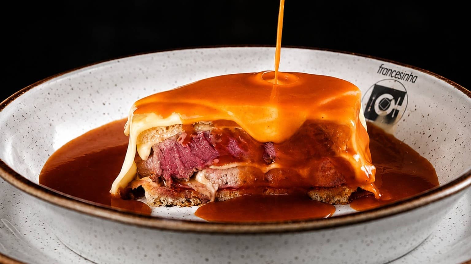 Francesinha served at Francesinha Café in Porto with melted cheese and rich homemade sauce