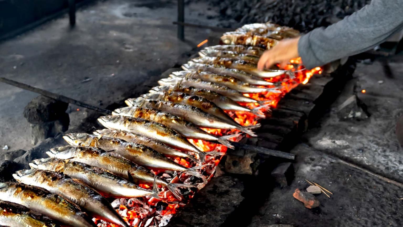 Grilled sardines being prepared over charcoal during Lisbon’s street parties in celebration of St. Anthony.