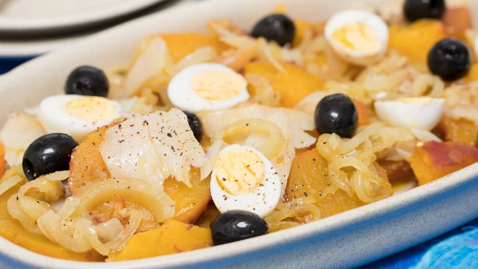 Traditional Bacalhau à Gomes de Sá prepared with codfish, potatoes, onions, olives, and boiled eggs
