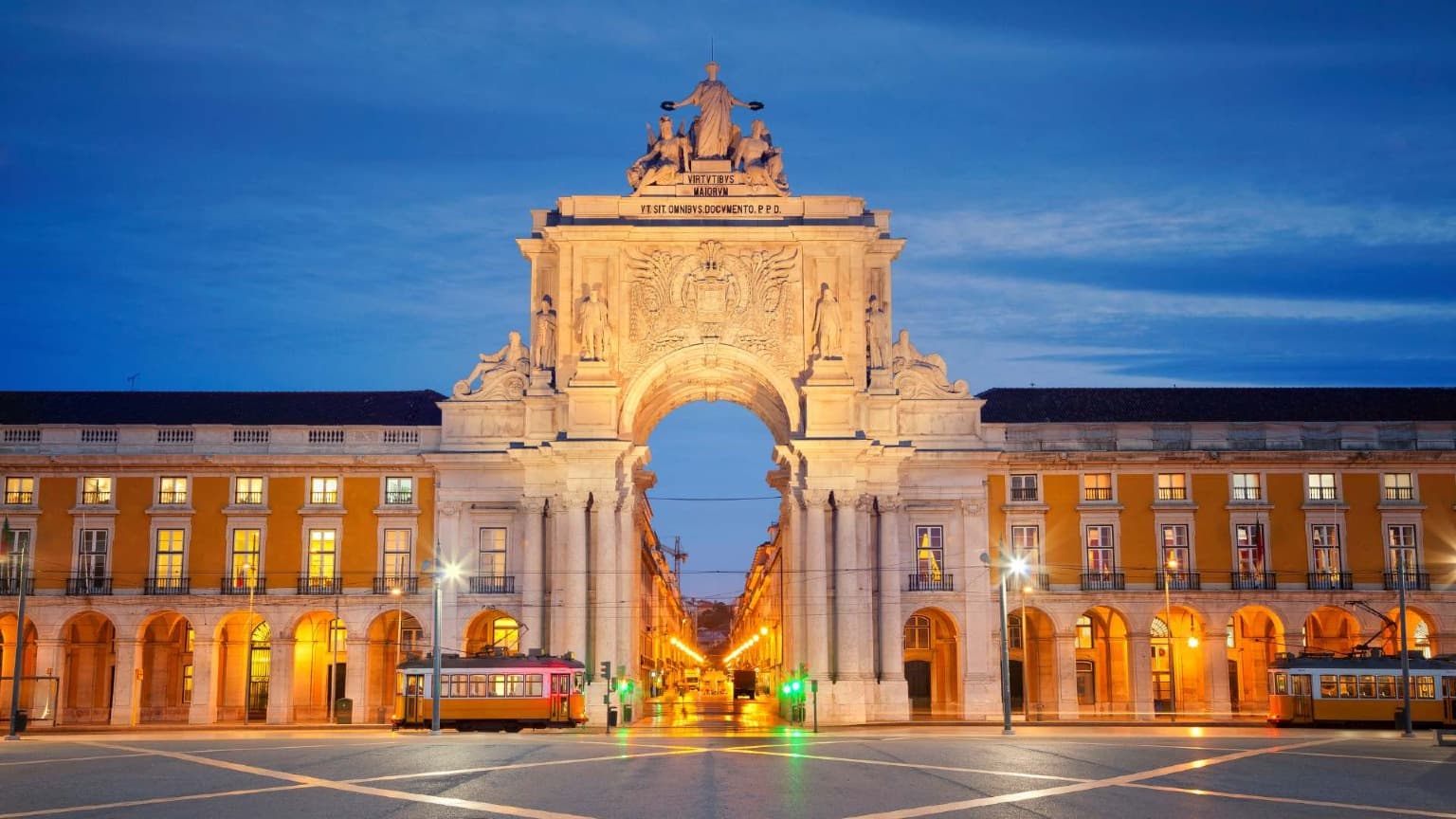 Praça do Comércio em Lisboa iluminada ao anoitecer, um dos principais locais de celebração da véspera de Ano Novo em Portugal.