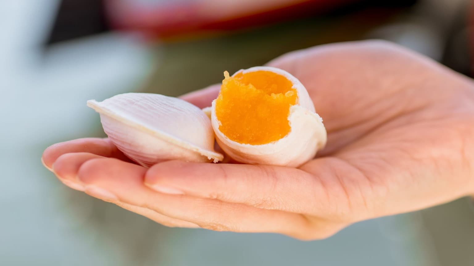 Dulce tradicional «Ovos Moles de Aveiro» en una oblea blanca, sostenido en la mano de una persona