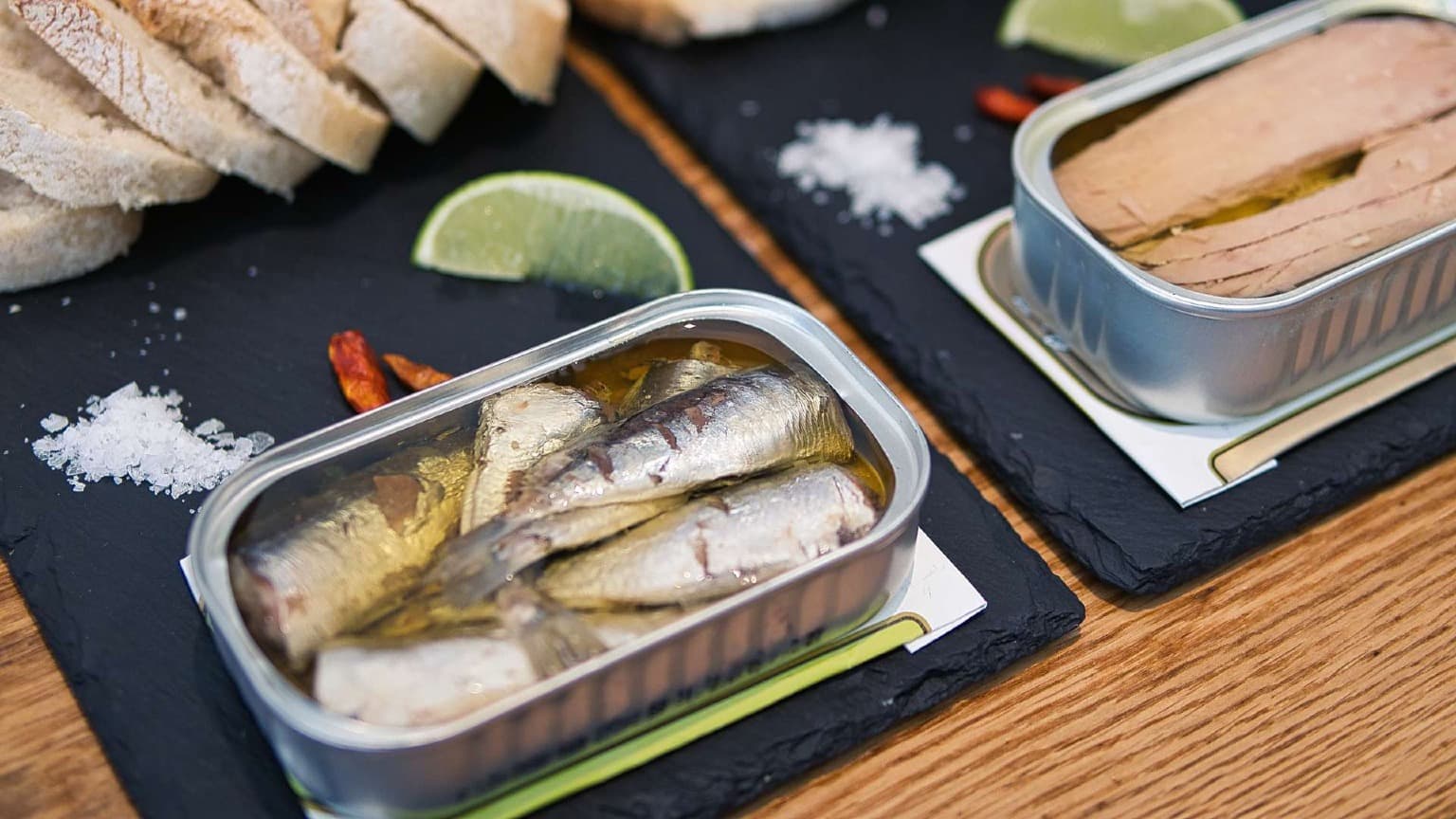 Degustación de conservas gourmet portuguesas y sardinas con pan y aceite de oliva durante un tour gastronómico por Oporto