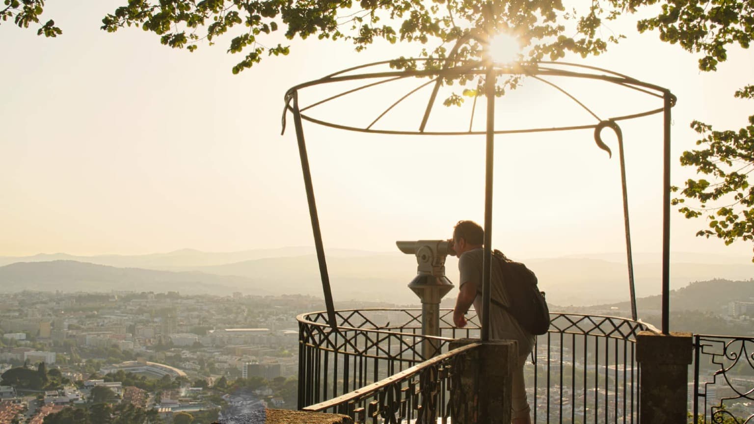 Voyageur appréciant la vue du coucher de soleil sur Braga depuis le point de vue de Bom Jesus do Monte.