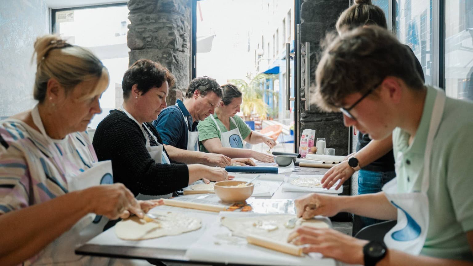 Participantes aprendiendo a elaborar auténticos Pastéis de Nata durante un taller de repostería en Funchal, Madeira