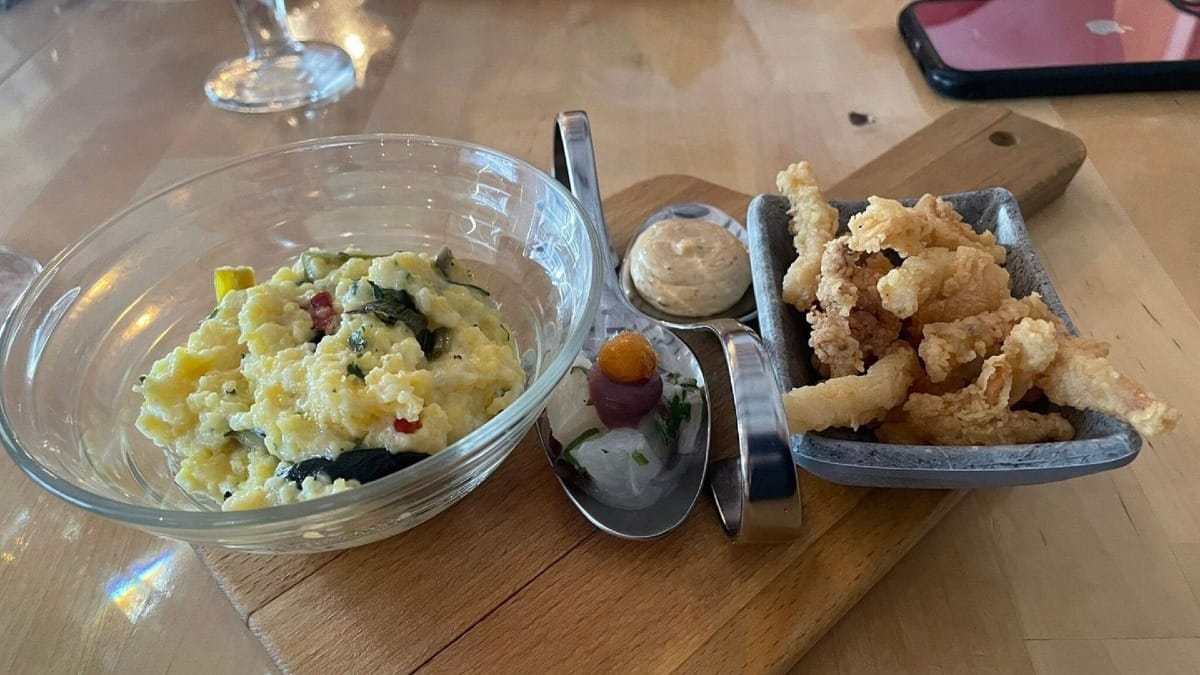 Prato de entrada com mariscos algarvios incluindo açorda cremosa, lulas fritas e cebola marinada