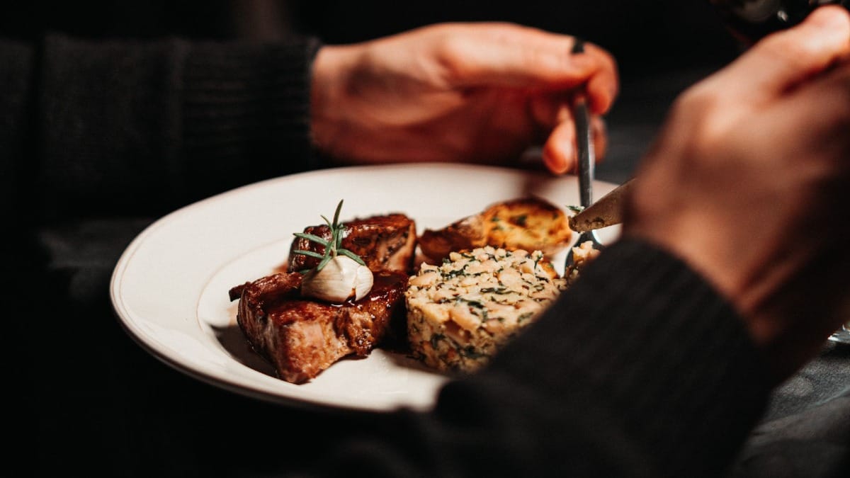 Invitado degustando un plato tradicional portugués mientras disfruta de un concierto de Fado en Oporto