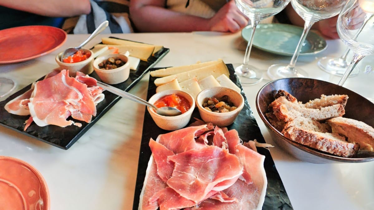 Embutidos, quesos y acompañamientos locales servidos con pan durante una cata de vinos en Oporto