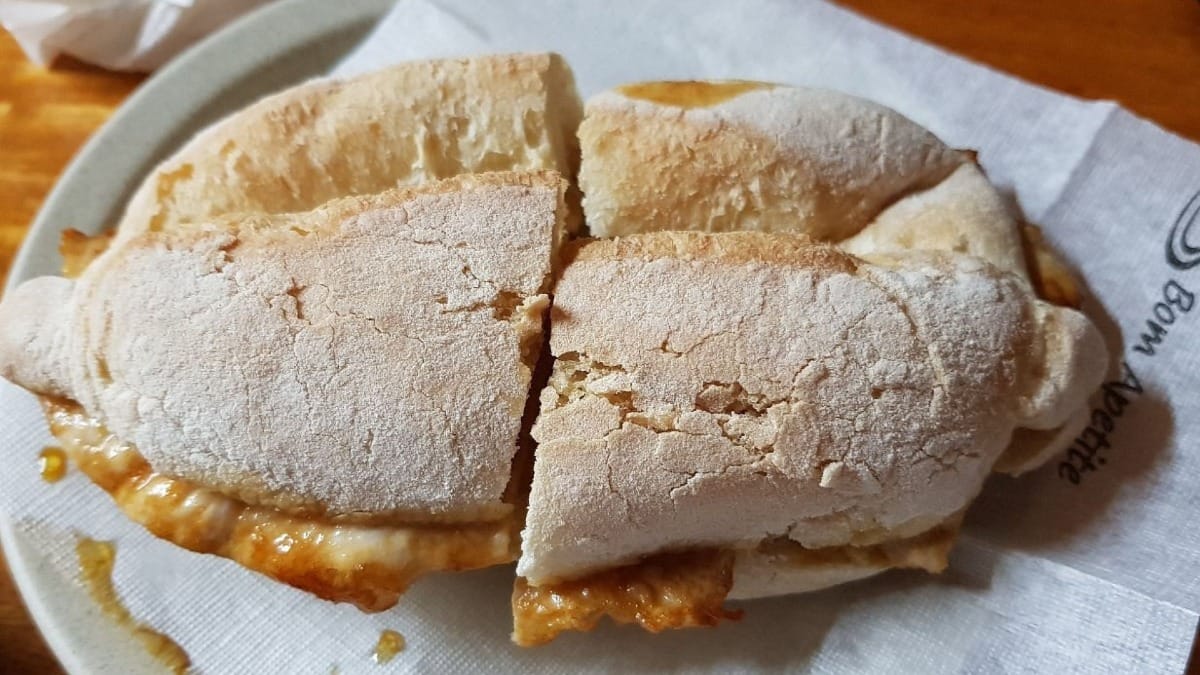 Sandes tradicional de bifana servida numa tasca local em Faro durante o tour