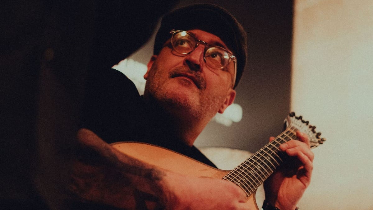 Fado guitar player focusing on the singer to create beautiful melodies during a live Fado concert in Porto