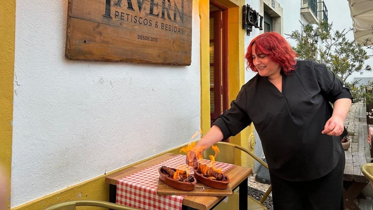 Chouriço a arder servido ao ar livre numa taberna tradicional em Faro