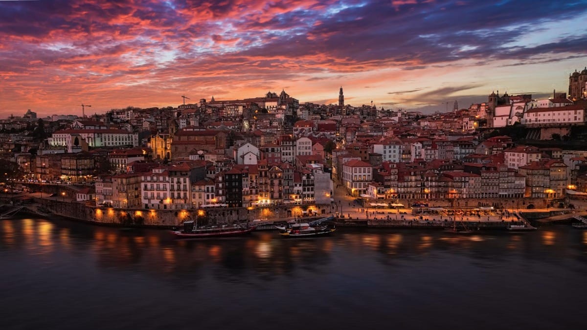 Vista deslumbrante do pôr do sol em Gaia sobre o Rio Douro e o Porto durante a visita guiada noturna com a Cooltour Oporto