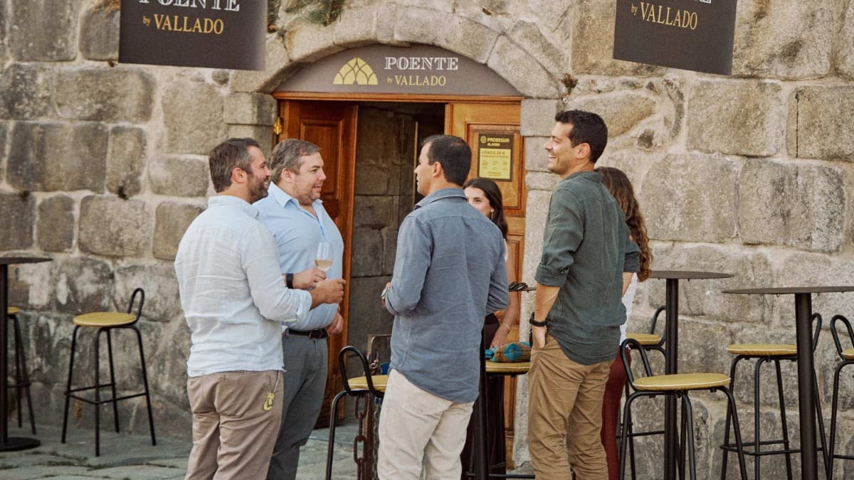 Historic façade of Poente by Vallado with people enjoying wine tasting outdoors