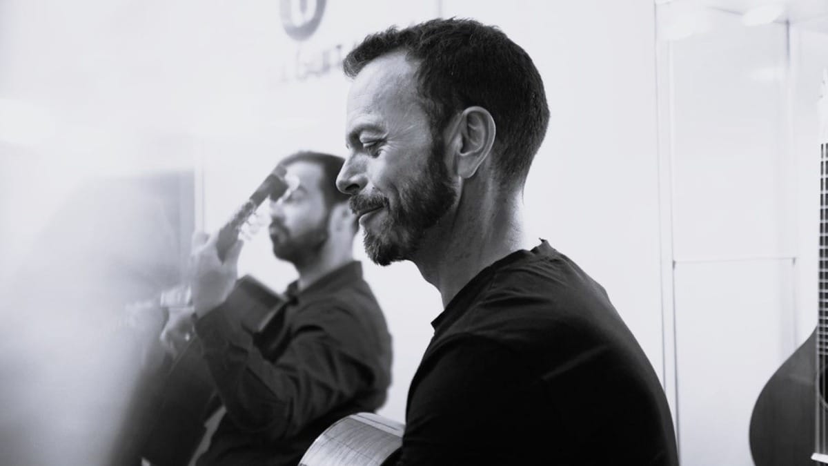 Portuguese guitar player smiling during a Fado concert at Casa da Guitarra in Porto