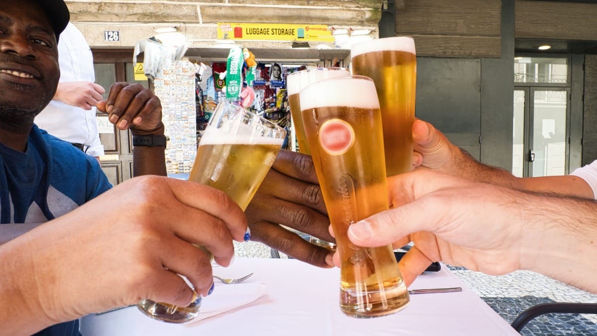 Invités trinquant avec une bière pression portugaise sur la terrasse d’un restaurant pendant le Food Tour de Cooltour Oporto